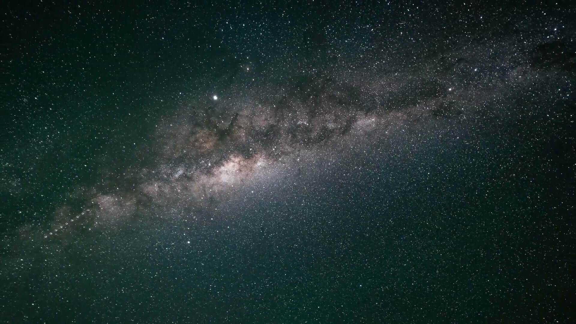 A stunning view of the Milky Way galaxy stretches diagonally across the night sky, showcasing a dense cluster of bright stars against a dark backdrop. Among them, Proxima stands out as part of this luminous band, surrounded by countless smaller, scattered stars.