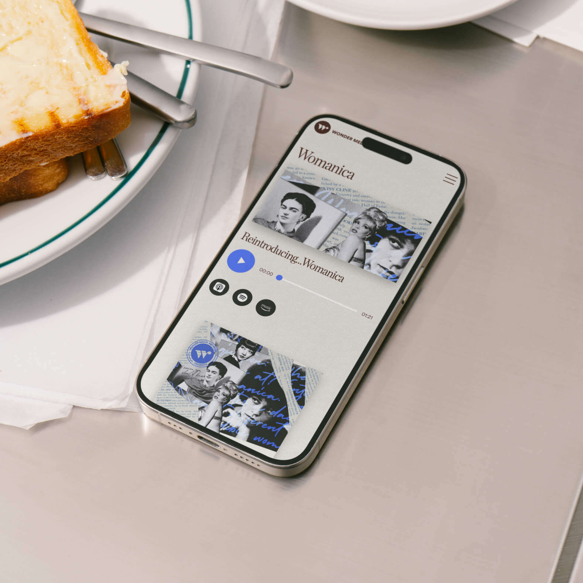 A smartphone on a table showing a podcast episode on the Wonder Media Network website.