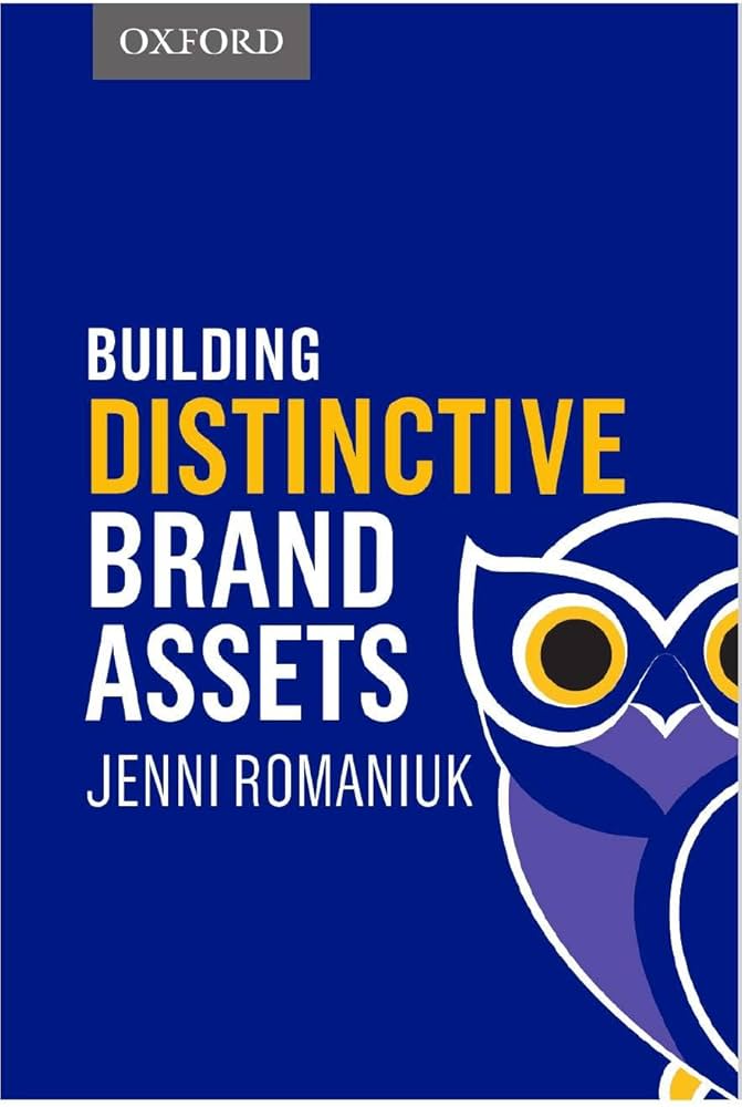 Book cover titled Building Distinctive Brand Assets by Jenni Romaniuk. Features a stylized blue and yellow owl on a dark blue background, with the Oxford logo at the top.
